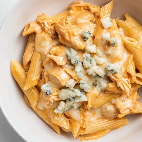 Hearty Buffalo Chicken Pasta served steaming hot, featuring tangy wing sauce, penne, and melted mozzarella for a comforting meal.  